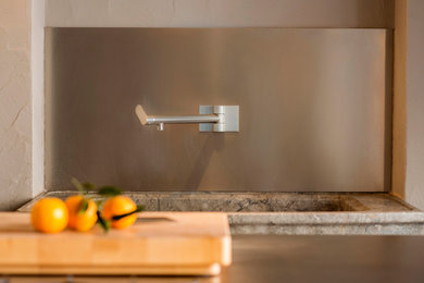 Esempio di un cucina con isola centrale design con lavello a vasca singola, ante in acciaio inossidabile, top in acciaio inossidabile e elettrodomestici in acciaio inossidabile