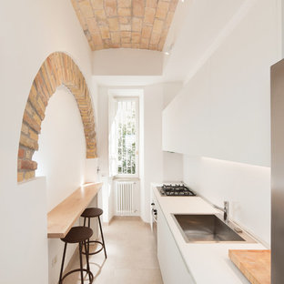 Foto di una cucina parallela mediterranea con pavimento in gres porcellanato, ante lisce, ante bianche, paraspruzzi bianco, elettrodomestici in acciaio inossidabile, top bianco, lavello da incasso, nessuna isola e pavimento beige