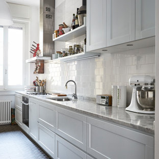Immagine di una cucina lineare tradizionale di medie dimensioni con lavello sottopiano, ante in stile shaker, ante bianche, paraspruzzi bianco, paraspruzzi con piastrelle diamantate, elettrodomestici in acciaio inossidabile, pavimento multicolore e top grigio