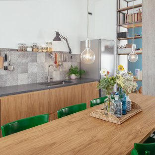 Idee per una cucina abitabile industriale con pavimento in gres porcellanato, pavimento grigio, lavello sottopiano, ante lisce, ante in legno chiaro, paraspruzzi multicolore e top grigio