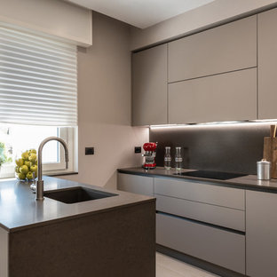 Immagine di una piccola cucina parallela contemporanea con lavello sottopiano, ante lisce, ante grigie, paraspruzzi grigio, paraspruzzi in lastra di pietra, penisola e top grigio