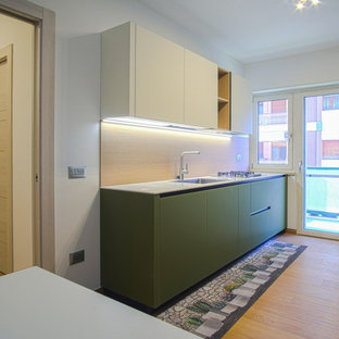 Design ideas for an expansive modern galley eat-in kitchen in Other with a drop-in sink, glass-front cabinets, green cabinets, solid surface benchtops, brown splashback, timber splashback, black appliances, porcelain floors, brown floor, white benchtop and recessed.