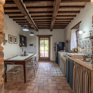 Esempio di una cucina country con lavello stile country, ante in stile shaker, ante blu, top piastrellato, paraspruzzi multicolore, pavimento in mattoni, nessuna isola, pavimento marrone, top multicolore e elettrodomestici neri