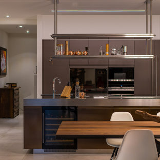 Idee per una grande cucina design con lavello sottopiano, ante lisce, ante grigie, top in acciaio inossidabile, elettrodomestici da incasso, pavimento in gres porcellanato, pavimento grigio e top grigio