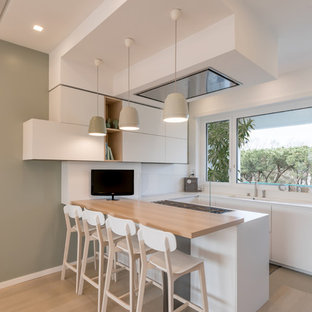 Foto di una cucina ad U contemporanea con ante lisce, ante bianche, paraspruzzi bianco, parquet chiaro, paraspruzzi con lastra di vetro, penisola e top bianco