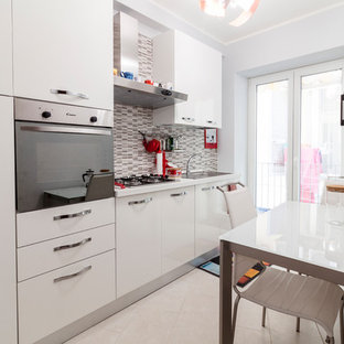 Esempio di una cucina lineare contemporanea con lavello da incasso, ante lisce, ante bianche, paraspruzzi grigio, paraspruzzi con piastrelle a listelli, elettrodomestici in acciaio inossidabile, nessuna isola, pavimento bianco e top bianco