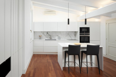 Small scandinavian single-wall open plan kitchen in Other with a submerged sink, flat-panel cabinets, white cabinets, composite countertops, porcelain splashback, stainless steel appliances, medium hardwood flooring, an island and white worktops.