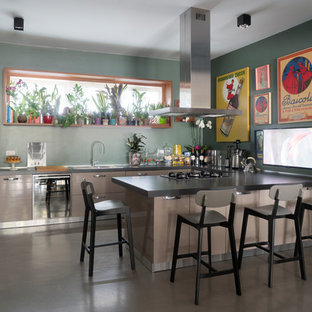 Immagine di una grande cucina design con lavello da incasso, ante marroni, pavimento in cemento, penisola, pavimento grigio, top grigio, ante lisce, paraspruzzi verde e elettrodomestici in acciaio inossidabile