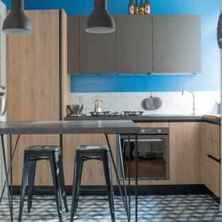 Foto di una piccola cucina contemporanea con lavello a vasca singola, ante in legno chiaro, top in laminato, paraspruzzi bianco, paraspruzzi in gres porcellanato, elettrodomestici in acciaio inossidabile, pavimento in gres porcellanato, penisola, pavimento blu, top grigio e ante lisce
