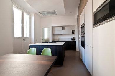 Esempio di una cucina contemporanea di medie dimensioni con lavello da incasso, ante a filo, top in marmo, elettrodomestici in acciaio inossidabile, pavimento in gres porcellanato, pavimento beige e soffitto ribassato