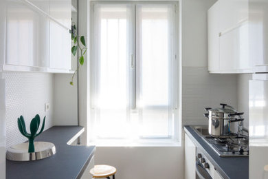 ローマにある低価格の小さなコンテンポラリースタイルのおしゃれなキッチン (シングルシンク、インセット扉のキャビネット、白いキャビネット、クオーツストーンカウンター、白いキッチンパネル、モザイクタイルのキッチンパネル、シルバーの調理設備、磁器タイルの床、アイランドなし、茶色い床、グレーのキッチンカウンター) の写真