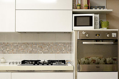 Ispirazione per una cucina moderna di medie dimensioni con ante lisce, top in laminato, paraspruzzi beige, elettrodomestici in acciaio inossidabile, pavimento in gres porcellanato, pavimento beige e top bianco