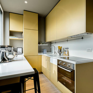 Foto di una cucina ad U design con ante grigie, elettrodomestici in acciaio inossidabile e top bianco