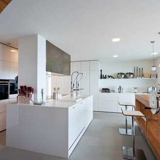 Idee per una cucina minimalista chiusa con ante lisce, ante bianche, 2 o più isole, pavimento grigio e top bianco