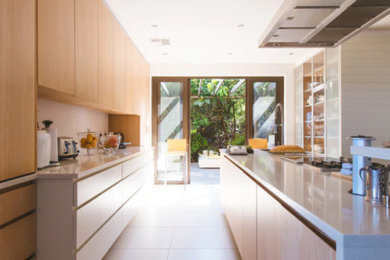 Esempio di una grande cucina minimal con lavello a doppia vasca, ante lisce, ante in legno chiaro, paraspruzzi beige, pavimento beige e top beige