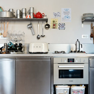 Foto di una piccola cucina lineare industriale con ante in acciaio inossidabile, top in acciaio inossidabile, paraspruzzi grigio, pavimento in cemento, nessuna isola, pavimento grigio, top grigio, ante lisce, paraspruzzi con piastrelle di metallo e elettrodomestici in acciaio inossidabile