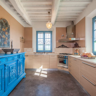 Foto di una cucina a L mediterranea di medie dimensioni con ante lisce, pavimento in cemento, nessuna isola, pavimento grigio, top beige, lavello a doppia vasca, ante in legno chiaro, paraspruzzi beige e elettrodomestici in acciaio inossidabile