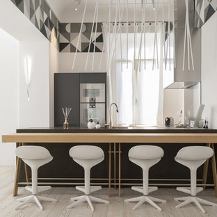 Esempio di una cucina parallela minimal con ante lisce, ante grigie, top in legno, elettrodomestici in acciaio inossidabile, penisola, pavimento beige e top beige