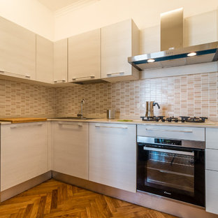 Esempio di una cucina a L design con ante lisce, elettrodomestici in acciaio inossidabile, nessuna isola, top beige, lavello a doppia vasca, ante bianche, paraspruzzi beige, paraspruzzi con piastrelle a mosaico, pavimento in legno massello medio e pavimento marrone
