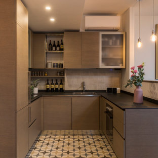 Foto di una piccola cucina ad U design con lavello a doppia vasca, ante lisce, ante in legno scuro, paraspruzzi beige, pavimento in gres porcellanato, nessuna isola, pavimento multicolore e top nero