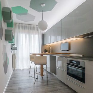 Esempio di una piccola cucina minimal con lavello a vasca singola, ante lisce, ante grigie, top in laminato, paraspruzzi grigio, elettrodomestici in acciaio inossidabile, pavimento in linoleum, penisola, pavimento grigio e top grigio