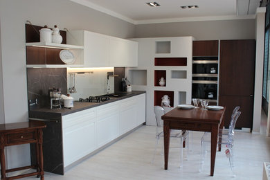 Esempio di una cucina a L contemporanea di medie dimensioni con top in laminato e elettrodomestici neri