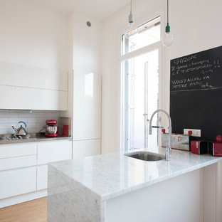 Idee per una cucina contemporanea con lavello sottopiano, ante lisce, ante bianche, paraspruzzi bianco, paraspruzzi con piastrelle diamantate, parquet chiaro, penisola, pavimento beige e top bianco