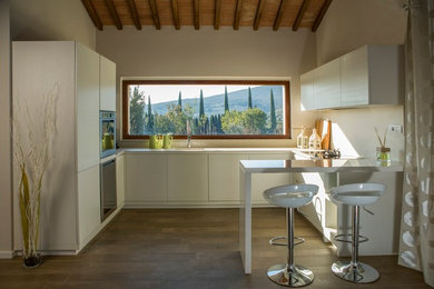 Foto de cocina de estilo de casa de campo de tamaño medio con fregadero encastrado, armarios con paneles lisos, puertas de armario blancas y suelo de madera oscura