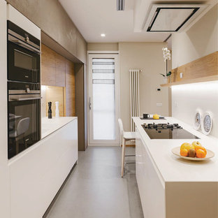 Esempio di una cucina parallela contemporanea con ante lisce, ante bianche, nessuna isola, pavimento grigio, top bianco, paraspruzzi bianco e elettrodomestici neri