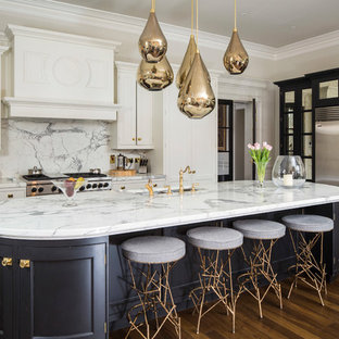Ispirazione per un ampio cucina con isola centrale minimal con lavello sottopiano, top in quarzo composito, paraspruzzi bianco, elettrodomestici in acciaio inossidabile, parquet scuro, top bianco, ante con riquadro incassato, ante bianche e pavimento marrone