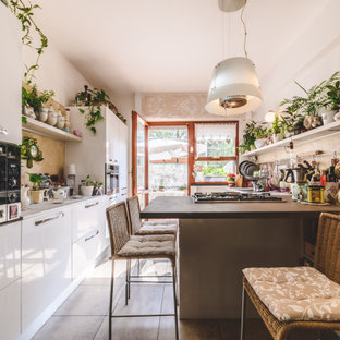 Foto di una piccola cucina parallela eclettica con ante bianche, top in marmo, paraspruzzi in marmo, elettrodomestici in acciaio inossidabile, pavimento con piastrelle in ceramica, penisola, pavimento grigio, top grigio, ante lisce e paraspruzzi beige