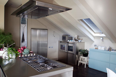 Immagine di una cucina contemporanea di medie dimensioni con lavello integrato, ante a filo, ante in acciaio inossidabile, top in acciaio inossidabile, elettrodomestici in acciaio inossidabile e pavimento grigio
