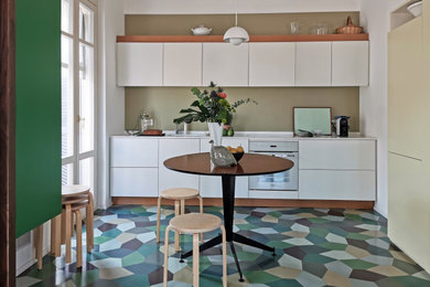 Immagine di una cucina a L design con ante lisce, ante bianche, elettrodomestici bianchi, pavimento multicolore e top bianco