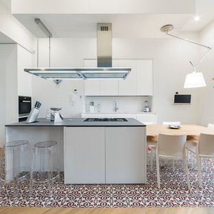 Foto di una cucina contemporanea con ante lisce, ante bianche, paraspruzzi bianco, paraspruzzi con lastra di vetro, elettrodomestici in acciaio inossidabile, pavimento con piastrelle in ceramica, pavimento multicolore e top grigio