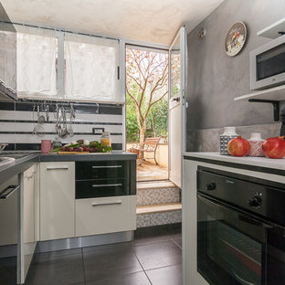 Esempio di una piccola cucina ad U design con ante lisce, ante nere, paraspruzzi bianco, elettrodomestici neri e pavimento grigio