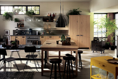 This is an example of a medium sized industrial single-wall open plan kitchen in Other with flat-panel cabinets, light wood cabinets, stainless steel worktops, stainless steel appliances and an island.
