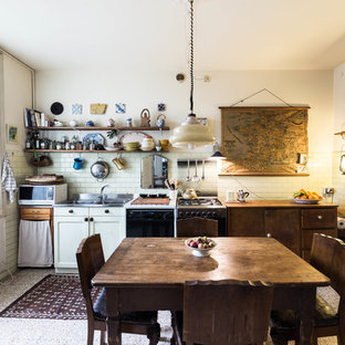 Esempio di una cucina eclettica con lavello a doppia vasca, ante lisce, ante in legno bruno, paraspruzzi bianco, paraspruzzi con piastrelle diamantate, elettrodomestici neri, nessuna isola e pavimento grigio