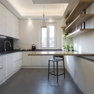 Esempio di un'ampia cucina contemporanea con top in quarzo composito, paraspruzzi nero, elettrodomestici in acciaio inossidabile, pavimento in gres porcellanato, pavimento grigio, top nero, ante lisce e ante bianche