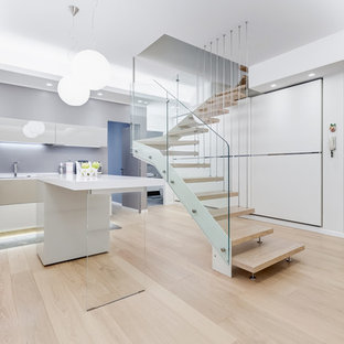 Esempio di una cucina minimalista con ante lisce, ante beige, parquet chiaro, pavimento beige e top bianco