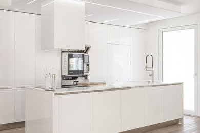 Idee per una cucina design di medie dimensioni con ante lisce, ante bianche e elettrodomestici in acciaio inossidabile
