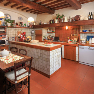 Immagine di una cucina mediterranea con lavello a doppia vasca, ante bianche, top piastrellato, paraspruzzi bianco, elettrodomestici bianchi, pavimento in terracotta, pavimento rosso, top bianco e travi a vista