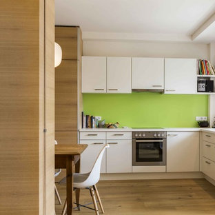 Esempio di una cucina minimalista con ante bianche, paraspruzzi verde, pavimento in legno massello medio, nessuna isola, top bianco, lavello da incasso, ante lisce e pavimento beige