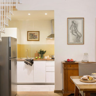 Esempio di una cucina minimal con lavello da incasso, ante lisce, ante bianche, top in legno, paraspruzzi a effetto metallico, paraspruzzi con lastra di vetro e pavimento grigio