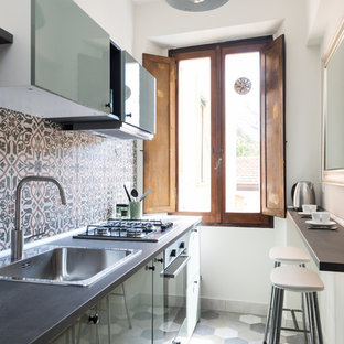 Foto di una piccola cucina mediterranea con lavello da incasso, ante lisce, ante verdi, paraspruzzi multicolore, elettrodomestici in acciaio inossidabile, pavimento multicolore e top nero