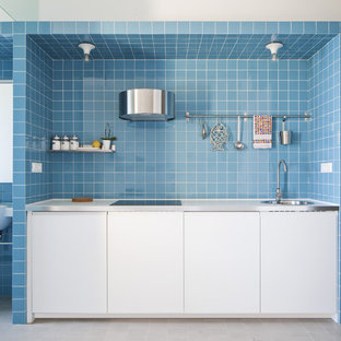 Idee per una piccola cucina lineare costiera con ante lisce, ante bianche, paraspruzzi blu, paraspruzzi con piastrelle in ceramica, elettrodomestici da incasso, nessuna isola, pavimento bianco e lavello a vasca singola