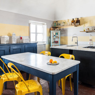 Esempio di una grande cucina abitabile bohémian con lavello sottopiano, top in marmo, pavimento in terracotta, pavimento rosso, top bianco, elettrodomestici bianchi e penisola