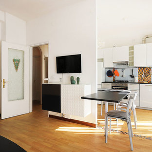 Idee per una cucina ad ambiente unico industriale con lavello da incasso, ante lisce, paraspruzzi multicolore, elettrodomestici in acciaio inossidabile, parquet chiaro e top nero