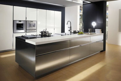 Idee per una grande cucina design con ante lisce, ante in acciaio inossidabile, elettrodomestici in acciaio inossidabile e parquet chiaro