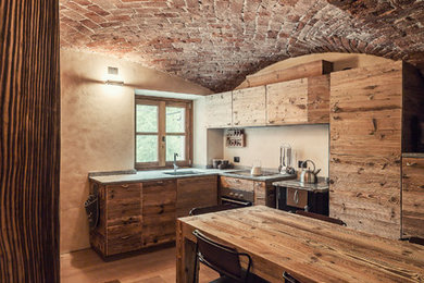 Immagine di una cucina rustica di medie dimensioni con ante lisce, ante in legno scuro, paraspruzzi beige, pavimento in legno massello medio, nessuna isola, pavimento marrone e elettrodomestici in acciaio inossidabile