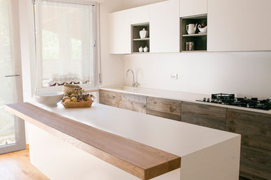Foto di una cucina design con parquet chiaro, lavello integrato, ante lisce, ante bianche, top in superficie solida e paraspruzzi bianco